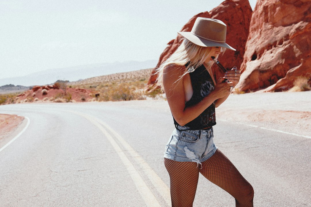 woman in black tank top and white denim shorts standing on road during daytime